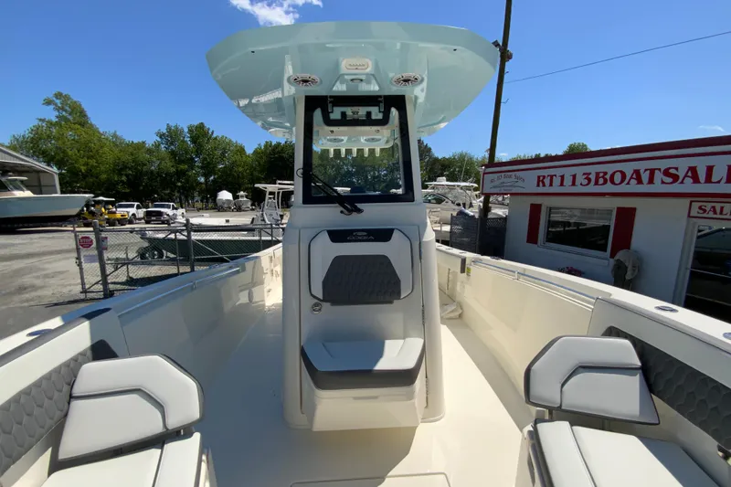 Slide: The Image of 2026 Cobia 245 Center Console boat at dealership, showcasing sleek design and seating. - 33