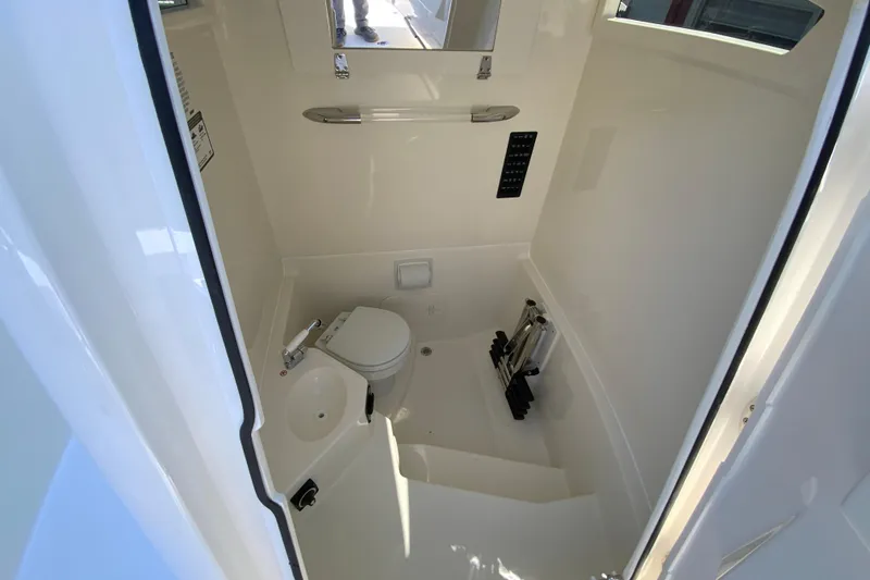 Slide: The Image of Interior of 2026 Cobia 245 Center Console boat featuring a compact marine toilet. - 39