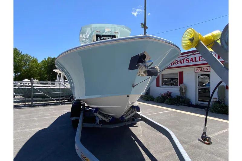 Slide: The Image of 2026 Cobia 245 Center Console boat on trailer at dealership under clear blue sky. - 4