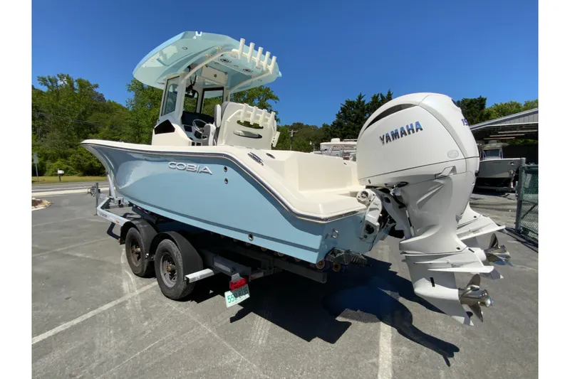 Slide: The Image of 2026 Cobia 245 Center Console boat with Yamaha engine on a trailer, parked outdoors. - 8