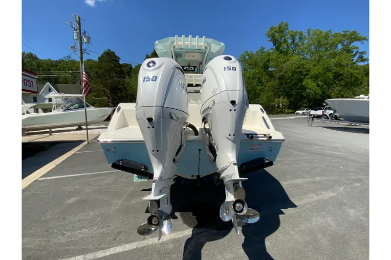 Slide: The Image of 2026 Cobia 245 Center Console boat with dual 150 horsepower engines, parked outdoors. - 9