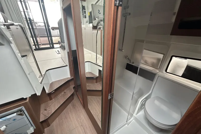 Slide: The Image of Interior of 2025 Beneteau Antares 11 Fly, featuring modern bathroom and wooden flooring. - 6