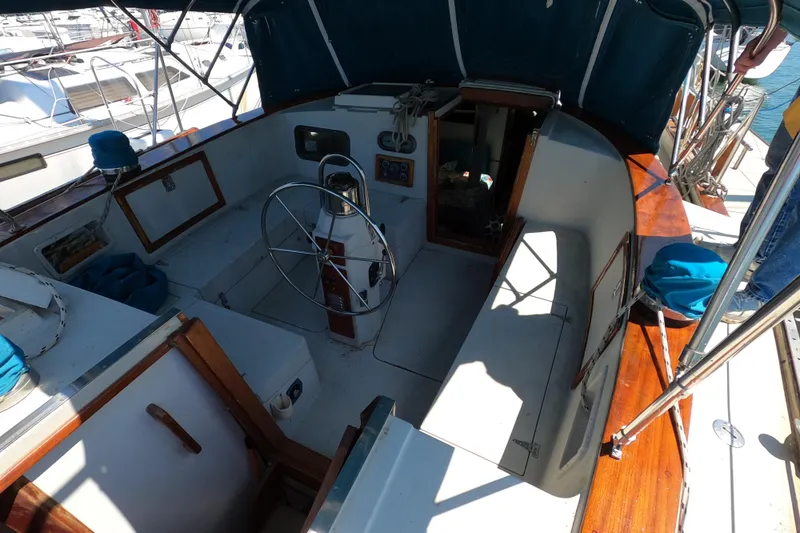 Slide: The Image of Cockpit of a 1978 CSY 44 sailboat with steering wheel and wooden accents. - 10