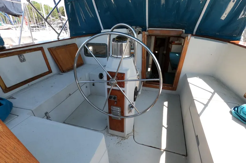 Slide: The Image of 1978 CSY 44 sailboat cockpit with steering wheel and blue canopy. - 11