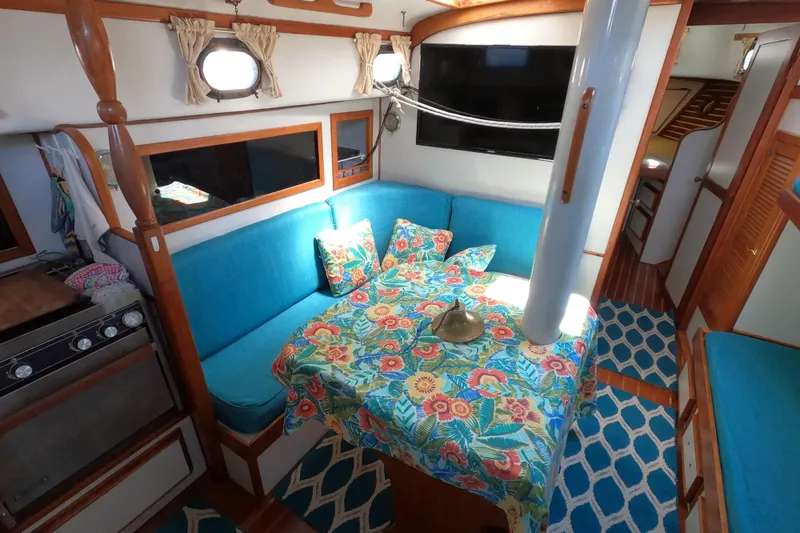 Slide: The Image of 1978 CSY 44 yacht interior with vibrant floral decor and cozy seating area. - 13