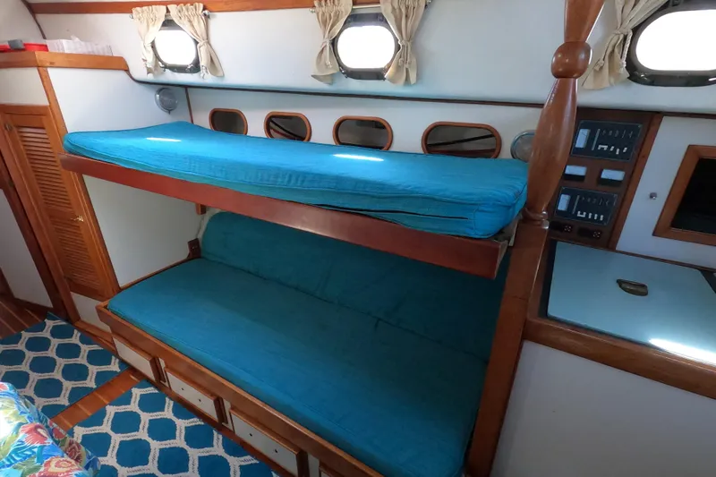 Slide: The Image of 1978 CSY 44 yacht interior with blue bunk beds and nautical decor. - 15