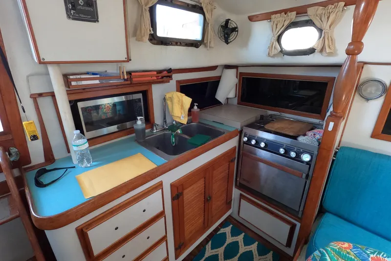 Slide: The Image of Interior of a 1978 CSY 44 sailboat kitchen with stove, sink, and storage. - 16
