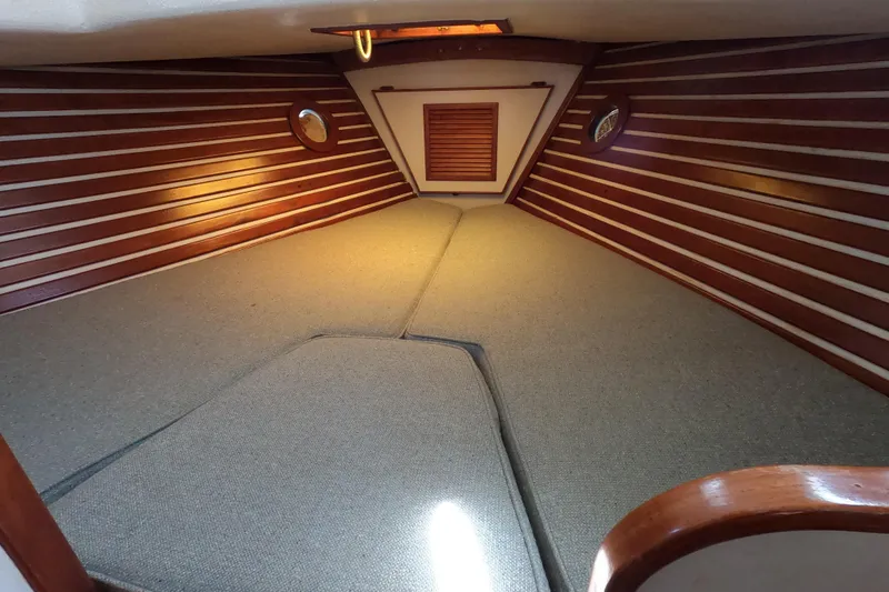 Slide: The Image of 1978 CSY 44 yacht interior with wooden paneling and cushioned sleeping area. - 20