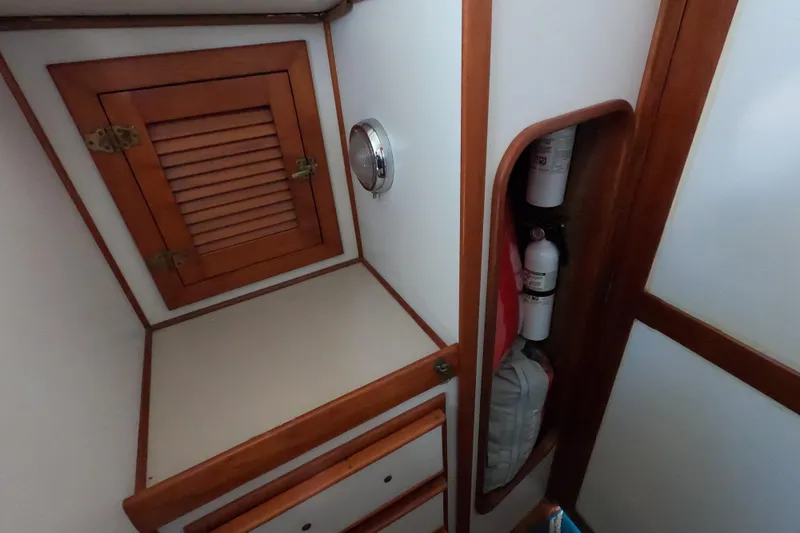 Slide: The Image of 1978 CSY 44 yacht interior with wooden cabinetry and fire extinguishers. - 22