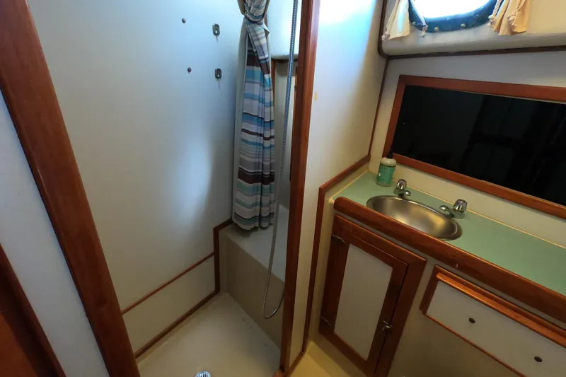 Slide: The Image of 1978 CSY 44 yacht bathroom with shower, sink, and porthole window. - 25
