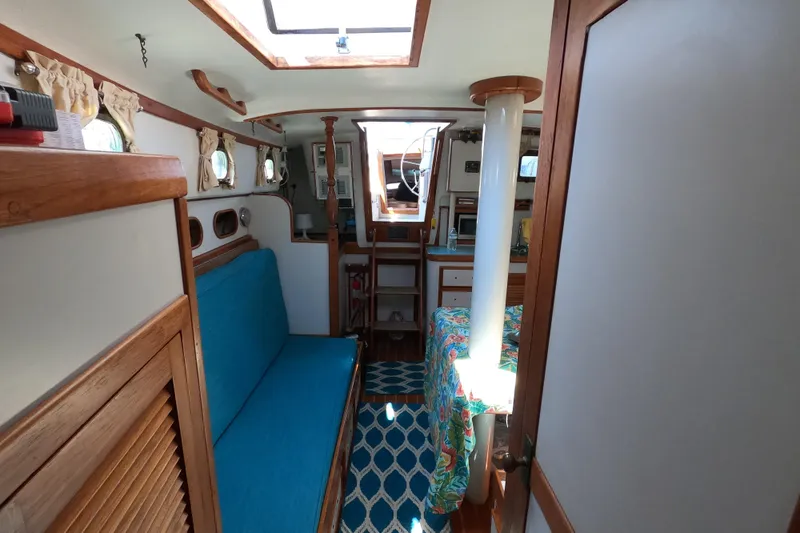 Slide: The Image of Interior of a 1978 CSY 44 sailboat with blue seating and nautical decor. - 26