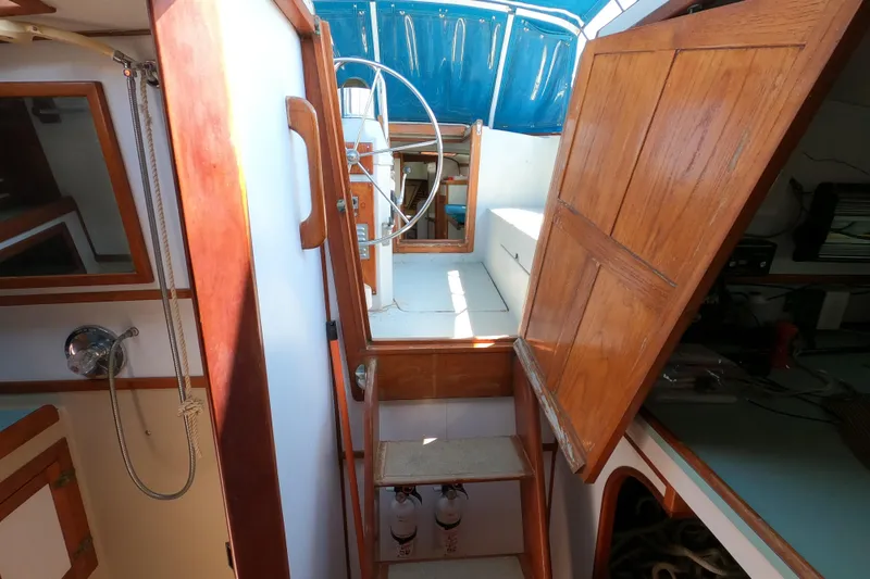 Slide: The Image of Interior view of a 1978 CSY 44 sailboat, featuring wooden cabinetry and a steering wheel. - 29