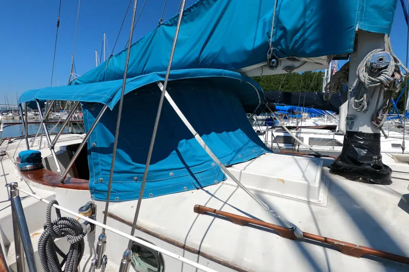 Slide: The Image of 1978 CSY 44 sailboat with blue canvas cover docked at marina. - 3