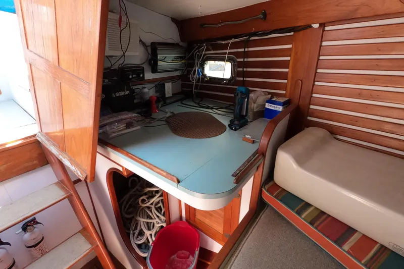 Slide: The Image of 1978 CSY 44 sailboat interior with navigation station and storage area. - 33