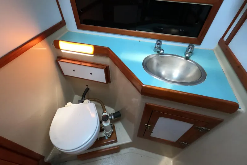 Slide: The Image of 1978 CSY 44 yacht bathroom with toilet, sink, and wooden accents. - 34