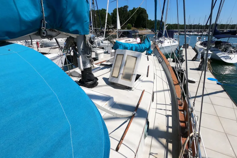 Slide: The Image of 1978 CSY 44 sailboat docked, featuring blue covers and wooden railings. - 5