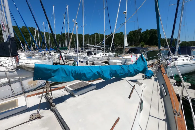 Slide: The Image of 1978 CSY 44 sailboat docked in a marina, surrounded by other sailboats. - 6