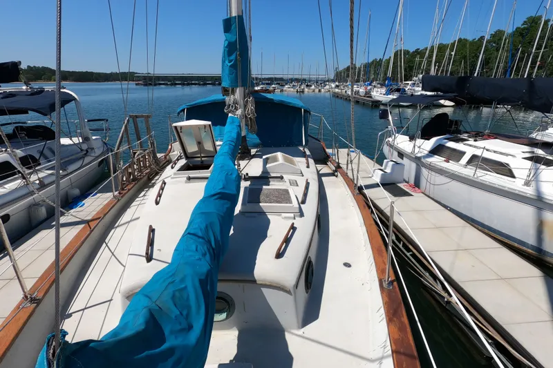 Slide: The Image of 1978 CSY 44 sailboat docked at marina, surrounded by other boats under clear blue sky. - 8