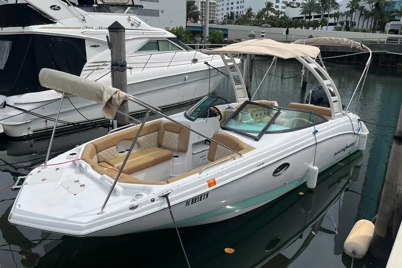 The Image of 2024 NauticStar 243 DC boat docked in marina, featuring beige seating and canopy. - 0