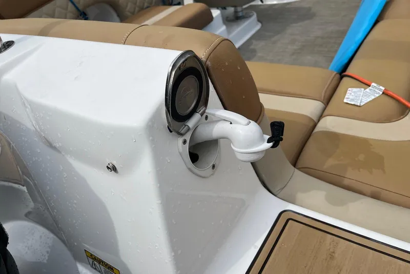Slide: The Image of 2024 NauticStar 243 DC boat interior with tan seating and a white deck. - 10