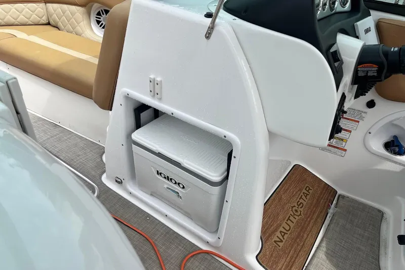 Slide: The Image of 2024 NauticStar 243 DC boat interior with Igloo cooler and cushioned seating. - 11