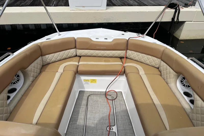 Slide: The Image of 2024 NauticStar 243 DC boat interior with tan quilted seating and cup holders. - 4