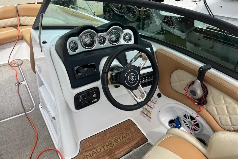 Slide: The Image of 2024 NauticStar 243 DC boat interior with steering wheel and dashboard controls. - 5