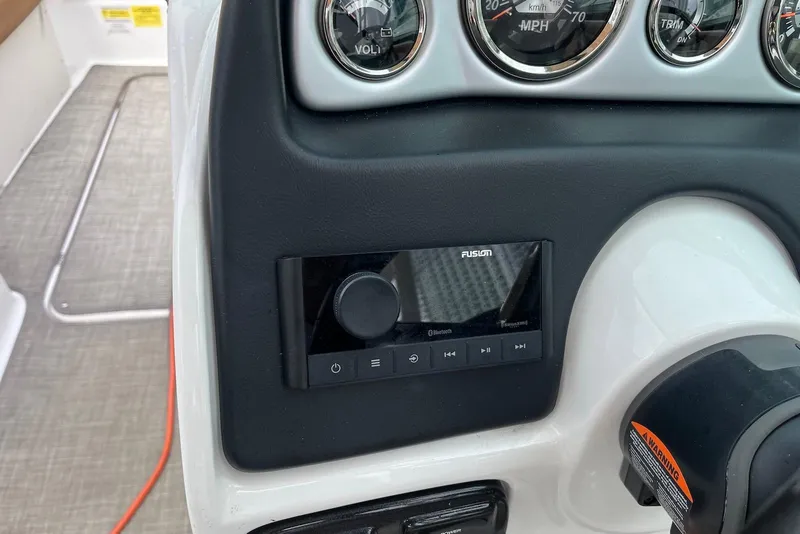 Slide: The Image of 2024 NauticStar 243 DC dashboard with Fusion audio system and gauges. - 6