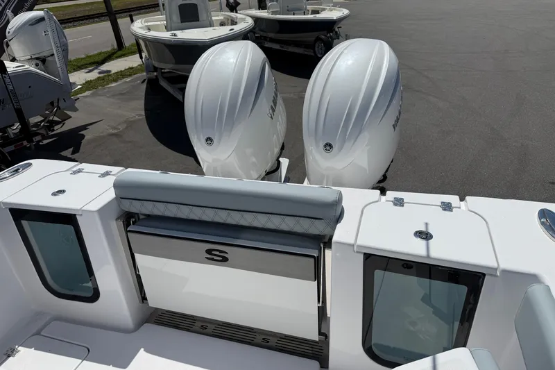 Slide: The Image of 2026 Sportsman Open 262 Center Console boat with dual outboard engines, docked in a marina. - 4