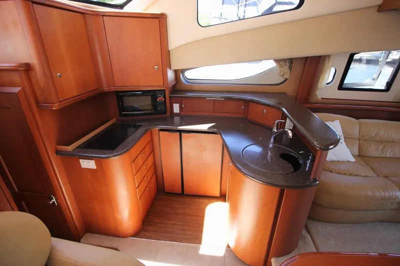 Slide: The Image of Luxurious 2006 Silverton 38 Sport Bridge yacht interior with modern kitchen and seating area. - 10