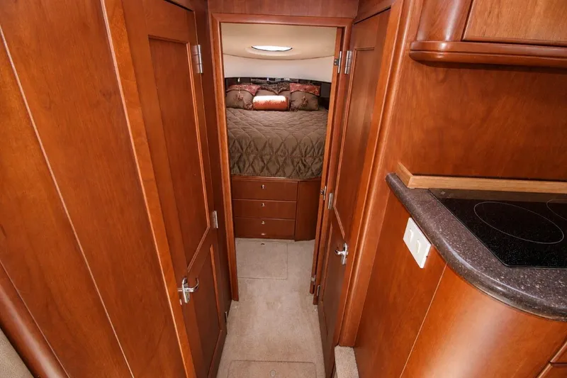 Slide: The Image of Interior of 2006 Silverton 38 Sport Bridge yacht with wood cabinetry and cozy bedroom. - 12
