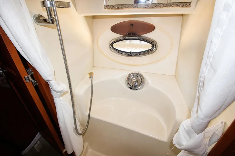 Slide: The Image of 2006 Silverton 38 Sport Bridge shower area with porthole and curtain. - 16