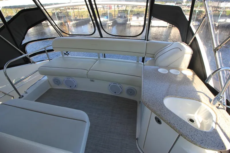 Slide: The Image of 2006 Silverton 38 Sport Bridge interior with seating, sink, and waterfront view. - 18
