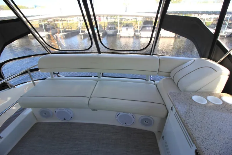 Slide: The Image of 2006 Silverton 38 Sport Bridge interior with cushioned seating and water view. - 19