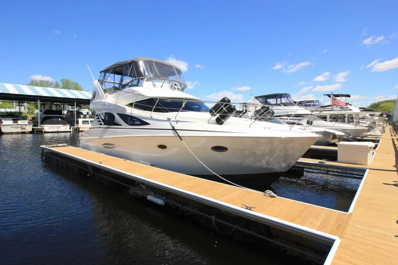 Slide: The Image of 2006 Silverton 38 Sport Bridge yacht docked at marina under clear blue sky. - 2