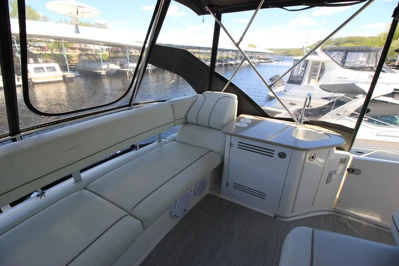 Slide: The Image of 2006 Silverton 38 Sport Bridge interior with seating and kitchenette, docked at marina. - 20
