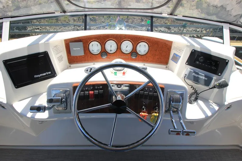 Slide: The Image of Helm of 2006 Silverton 38 Sport Bridge with Raymarine navigation system and classic steering wheel. - 21