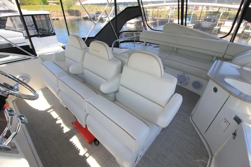 Slide: The Image of 2006 Silverton 38 Sport Bridge interior with plush white seating and modern helm. - 26