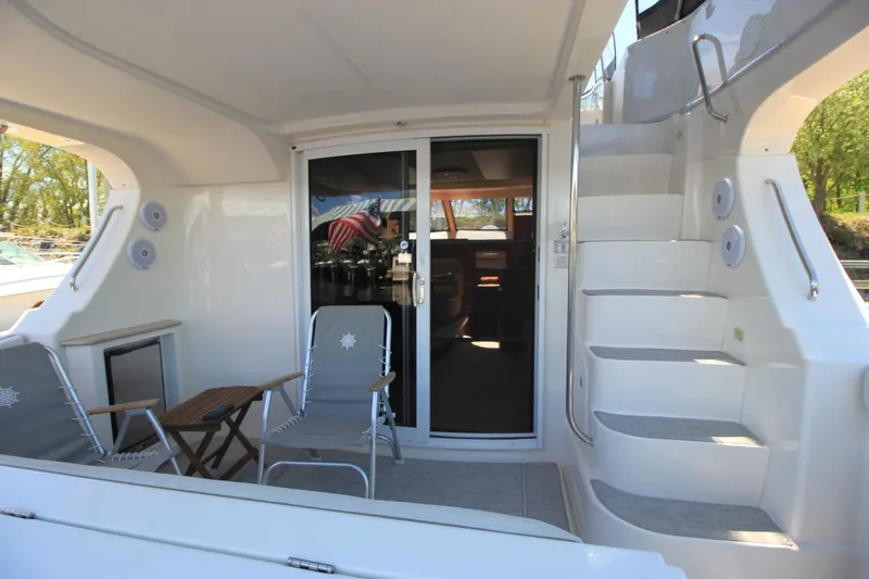 Slide: The Image of 2006 Silverton 38 Sport Bridge yacht interior with seating, table, and stairs. - 3