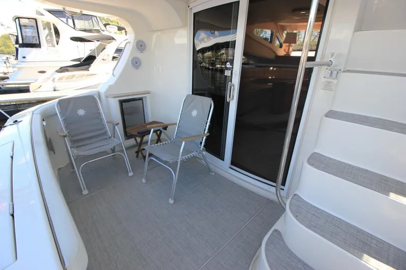 Slide: The Image of 2006 Silverton 38 Sport Bridge yacht deck with chairs and sliding glass door. - 5