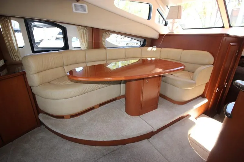 Slide: The Image of Luxurious interior of 2006 Silverton 38 Sport Bridge with plush seating and wooden table. - 8