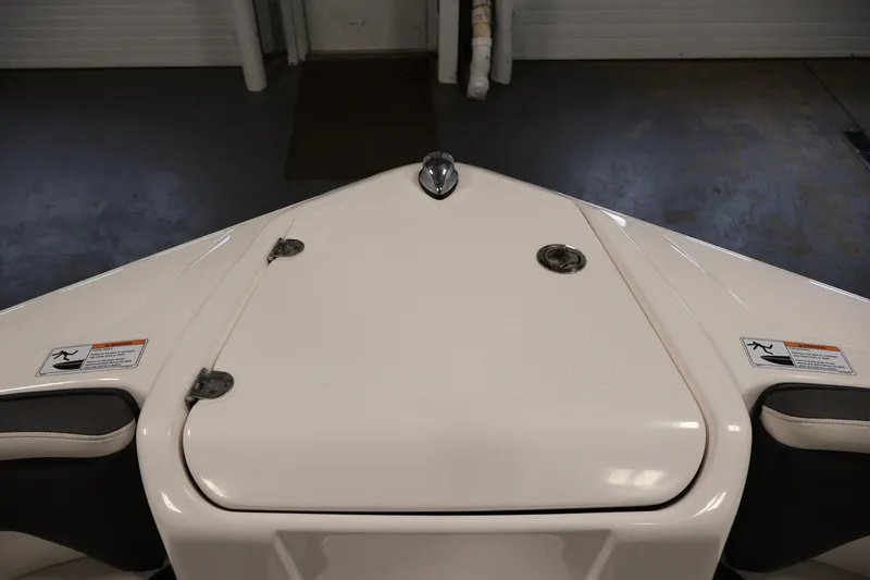 Slide: The Image of 2021 Yamaha Boats AR210 bow storage compartment in a showroom setting. - 12