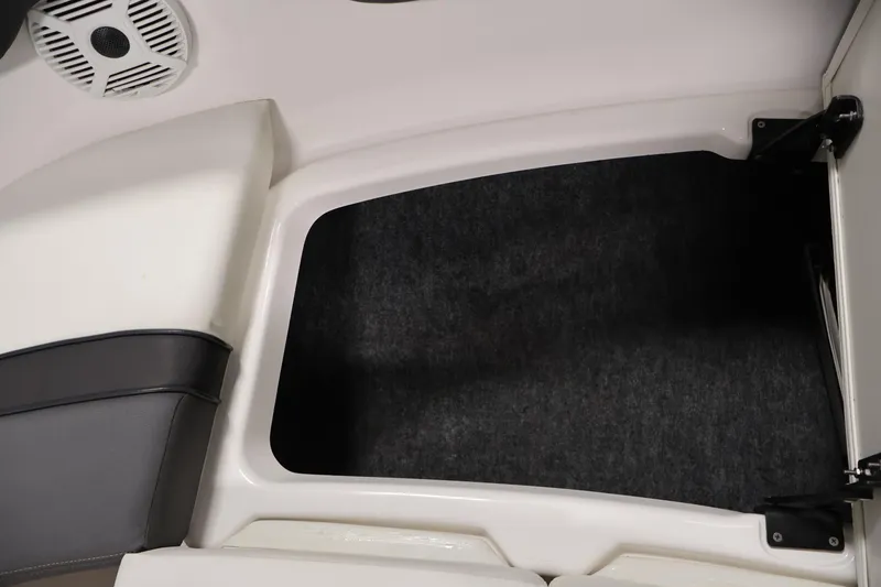 Slide: The Image of 2021 Yamaha AR210 boat storage compartment with speaker and cushioned seating. - 17