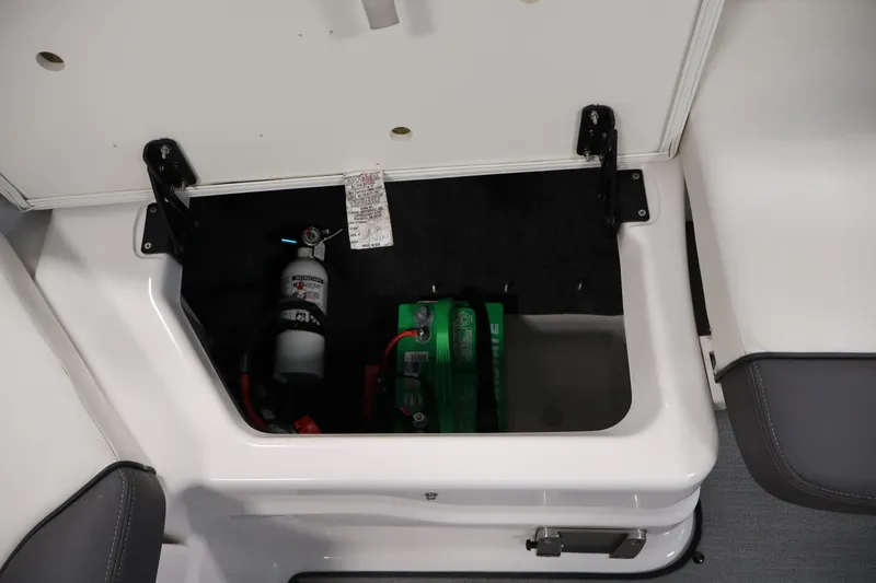 Slide: The Image of 2021 Yamaha AR210 boat storage compartment with fire extinguisher and battery. - 38