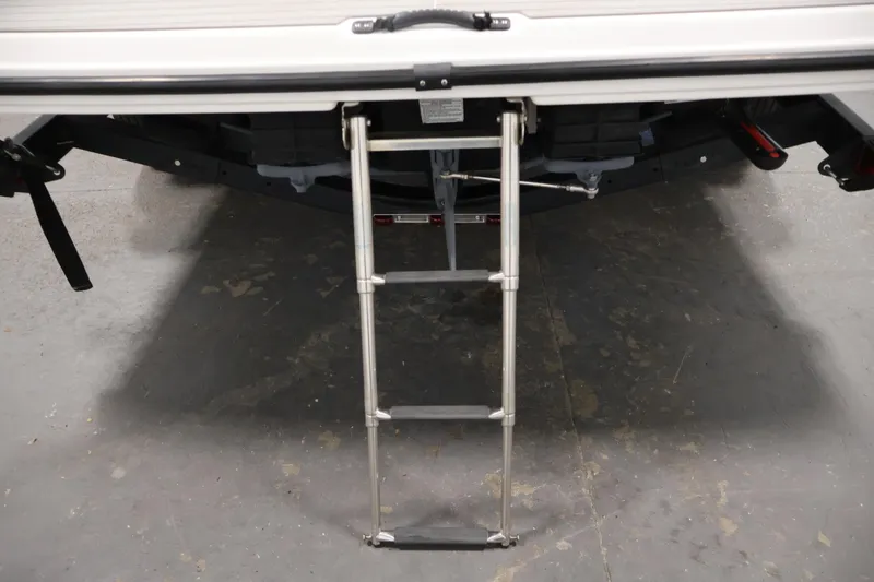 Slide: The Image of 2021 Yamaha Boats AR210 with extended swim ladder on a concrete floor. - 44