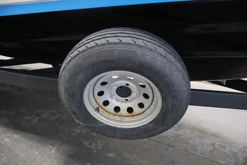Slide: The Image of Trailer wheel of a 2021 Yamaha Boats AR210, featuring a steel rim and tire. - 46