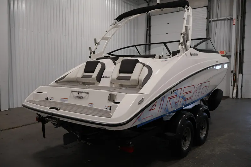 Slide: The Image of 2021 Yamaha Boats AR210 in a showroom, showcasing sleek design and modern features. - 5