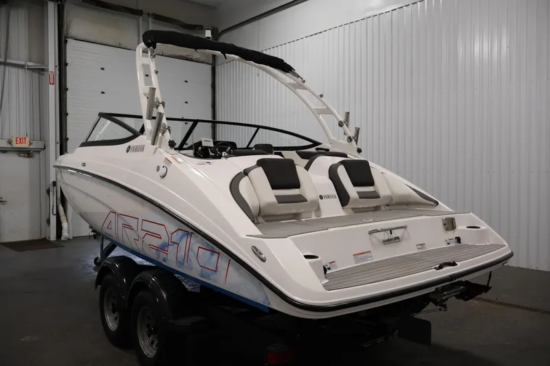 Slide: The Image of 2021 Yamaha Boats AR210 in a garage, showcasing sleek design and dual seating. - 7