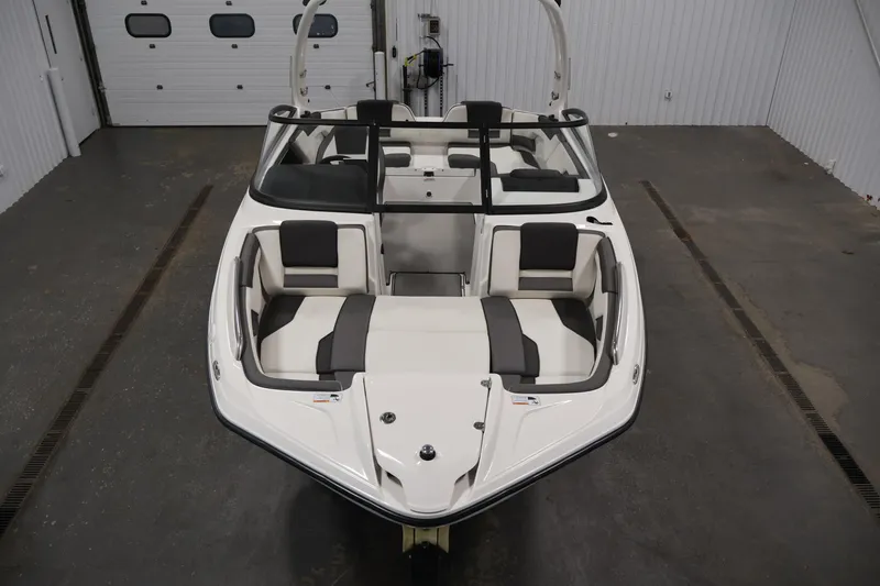 Slide: The Image of 2021 Yamaha Boats AR210 in a showroom, showcasing sleek design and spacious seating. - 9