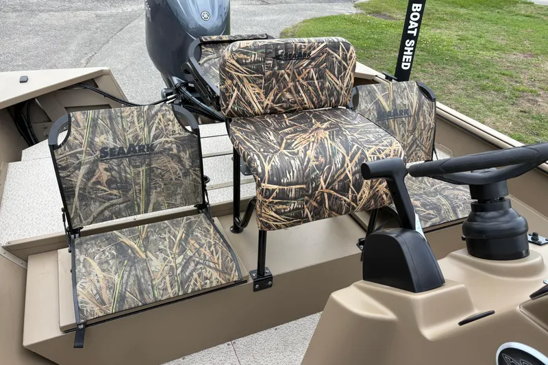 Slide: The Image of 2026 SeaArk Shadow 20V boat interior with camouflage seating and steering console. - 12